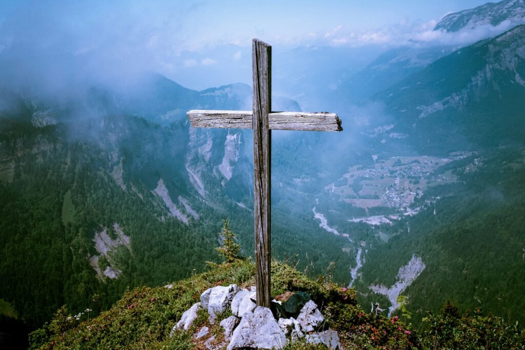 photo of brown wooden cross at cliff